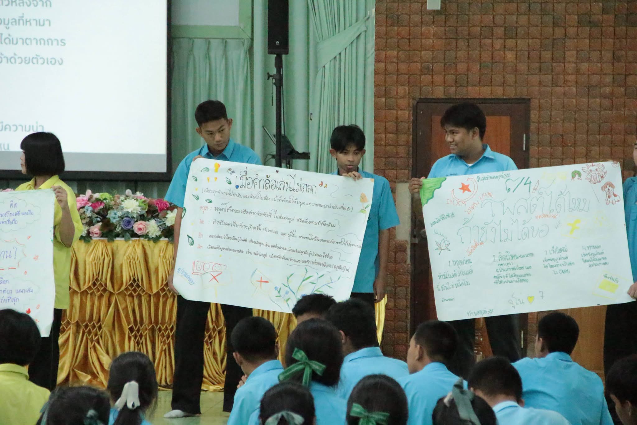 นักเรียนหลายกลุ่มแสดงโปสเตอร์ผลงานจากเวิร์กช็อป