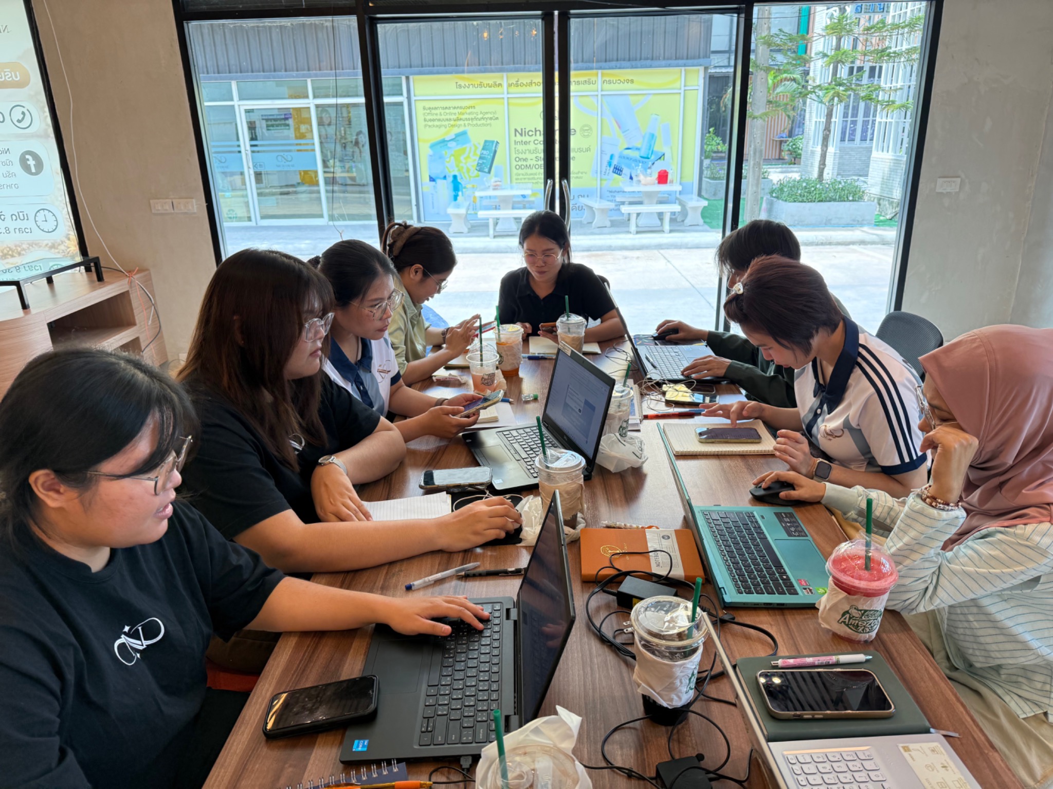 ผู้เข้าอบรมกำลังใช้คอมพิวเตอร์และโทรศัพท์ทำ Workshop ด้าน AI Branding and Marketing